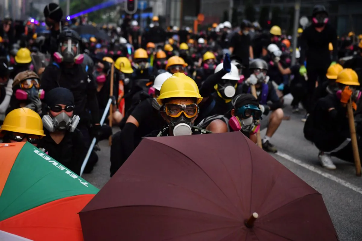 Protesters with umbrellas and protective gear face off with riot police at Kowloon Bay in Hong Kong on August 24, 2019. (Lillian Suwanrumpha/AFP/Getty Images)
