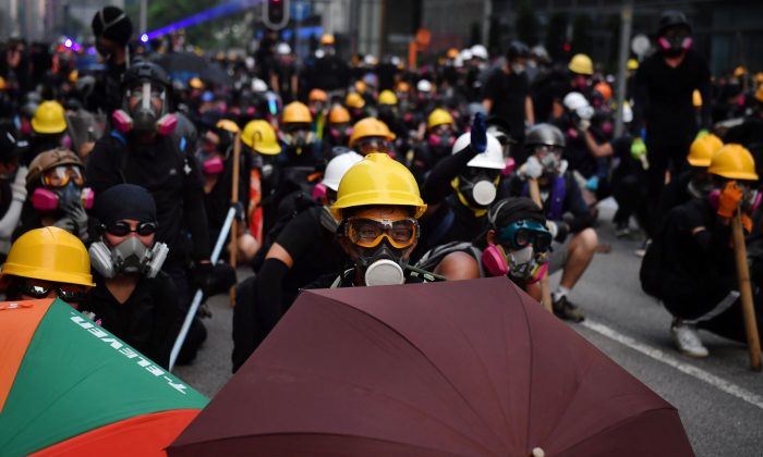 Protesters with umbrellas and protective gear face off with riot police at Kowloon Bay in Hong Kong on August 24, 2019. (Lillian Suwanrumpha/AFP/Getty Images)