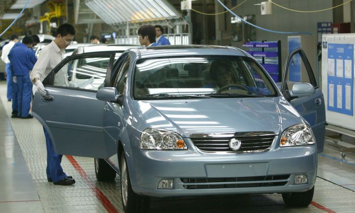 Workers work at a product line of Buick Excelles at Jinqiao South Vehicle Plant of Shanghai General Motors Corp. in Shanghai, China on May 28, 2005. (China Photos/Getty Images)