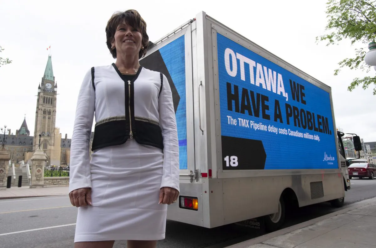 Alberta Energy Minister Sonya Savage stands in front of a billboard vehicle showing a campaign the Alberta government is undertaking in Ottawa on May 29, 2019. (The Canadian Press/Adrian Wyld)
