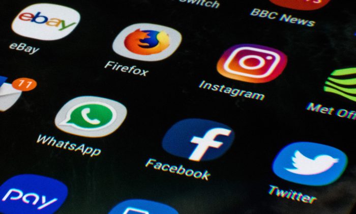 A mobile phone screen displays the icons for the social networking apps Facebook, Twitter and Instagram on March 22, 2018. (Oli Scarff/AFP/Getty Images)