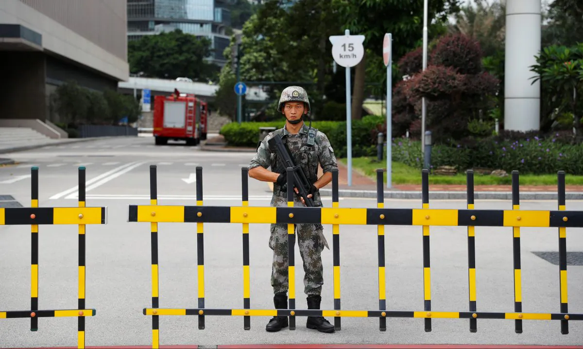 A Chinese People's Liberation Army (PLA) soldier guards the entrance to the PLA Hong Kong Garrison headquarters in the Central Business District in Hong Kong on Aug. 29, 2019. (Anushree Fadnavis/Reuters)