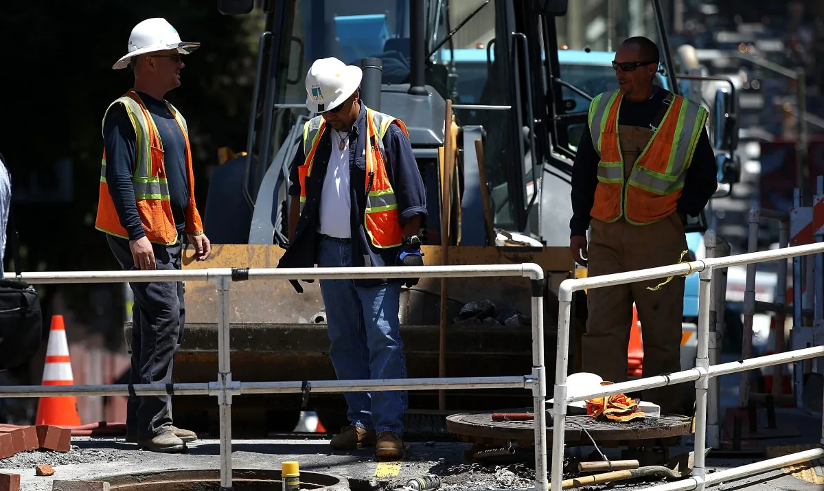 Pacific Gas and Electric (PG&E) workers look into a hole at a job site in San Francisco, Calif., on July 30, 2014. (Justin Sullivan/Getty Images)