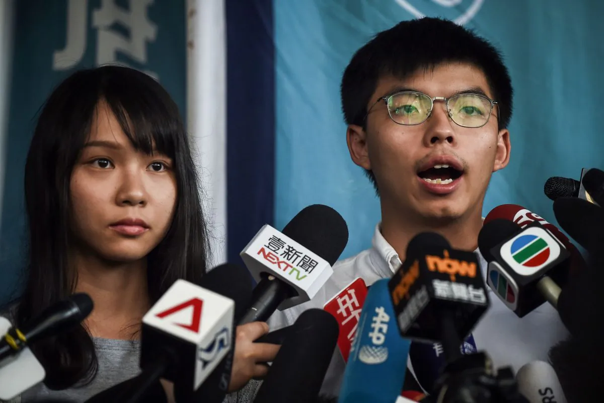 Pro-democracy activists Agnes Chow (L) and Joshua Wong (R) speak to the press after they were released on bail at the Eastern Magistrates Courts in Hong Kong on Aug. 30, 2019. (Lillian Suwanrumpha/AFP/Getty Images)