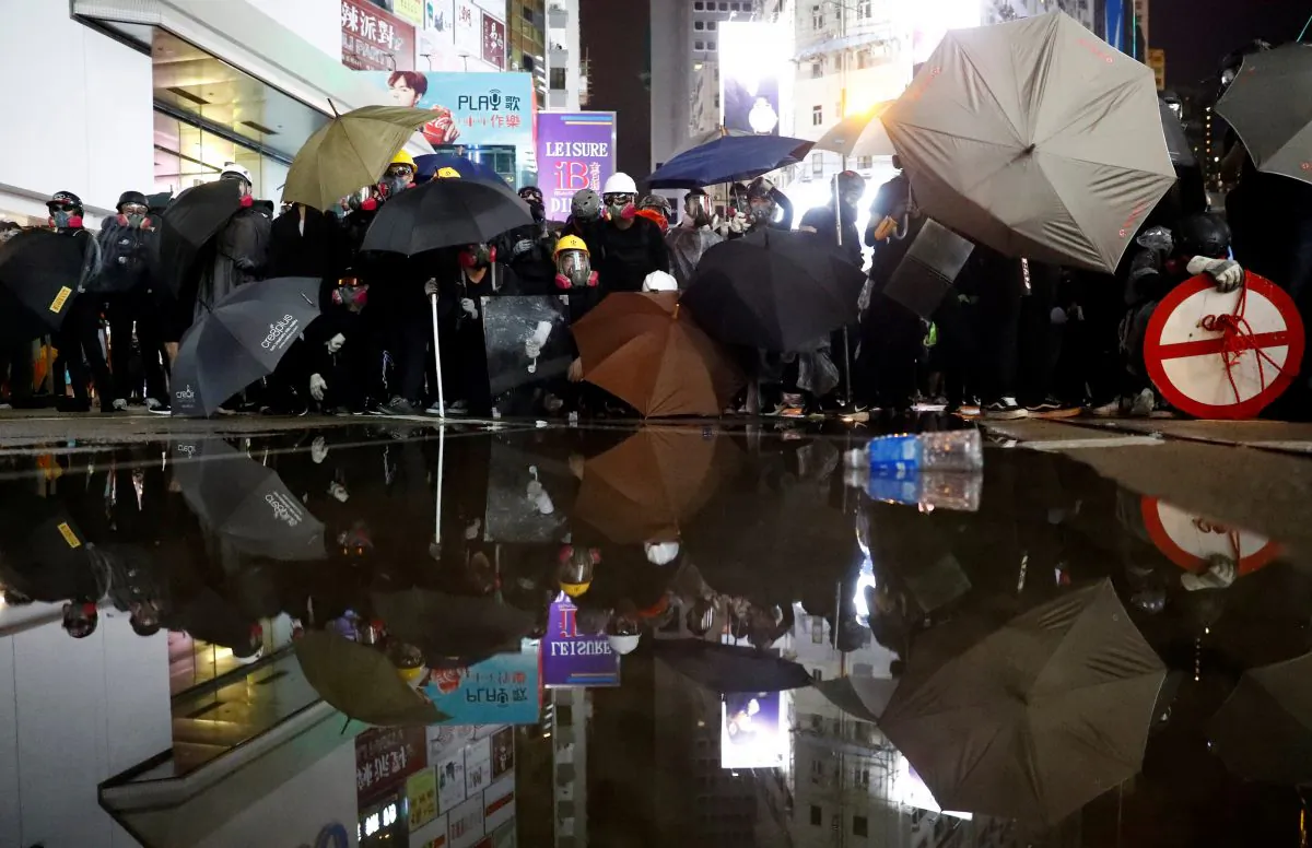 Demonstrators take cover during a protest in Hong Kong, on August 31, 2019. (REUTERS/Kai Pfaffenbach)