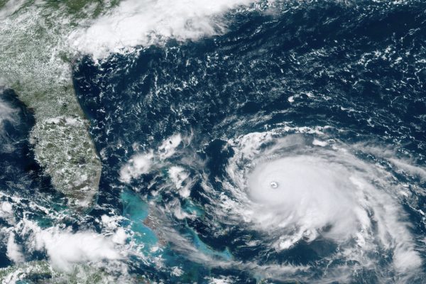 Hurricane Dorian, right, churning over the Atlantic Ocean,