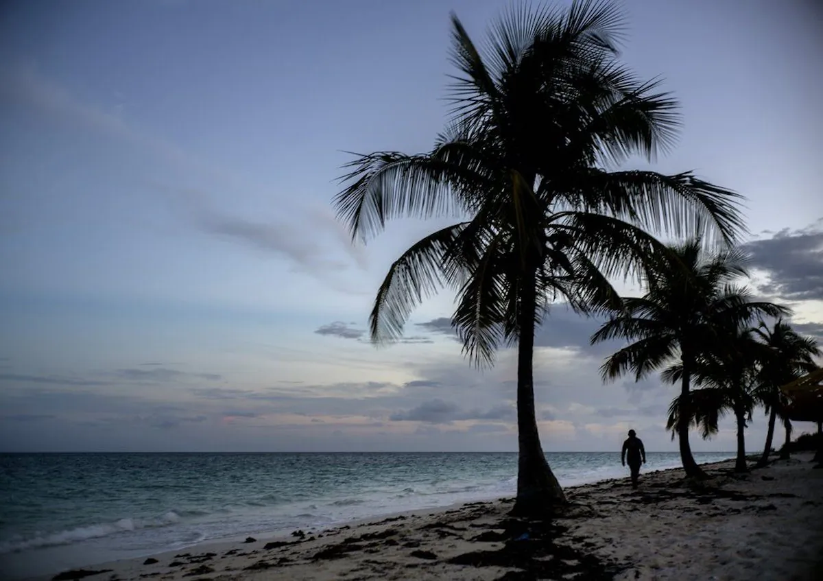 A woman walks along a beach before the arrival of Hurricane Dorian in Freeport, Grand Bahama, Bahamas, on Aug. 31, 2019. (Ramon Espinosa/AP Photo)