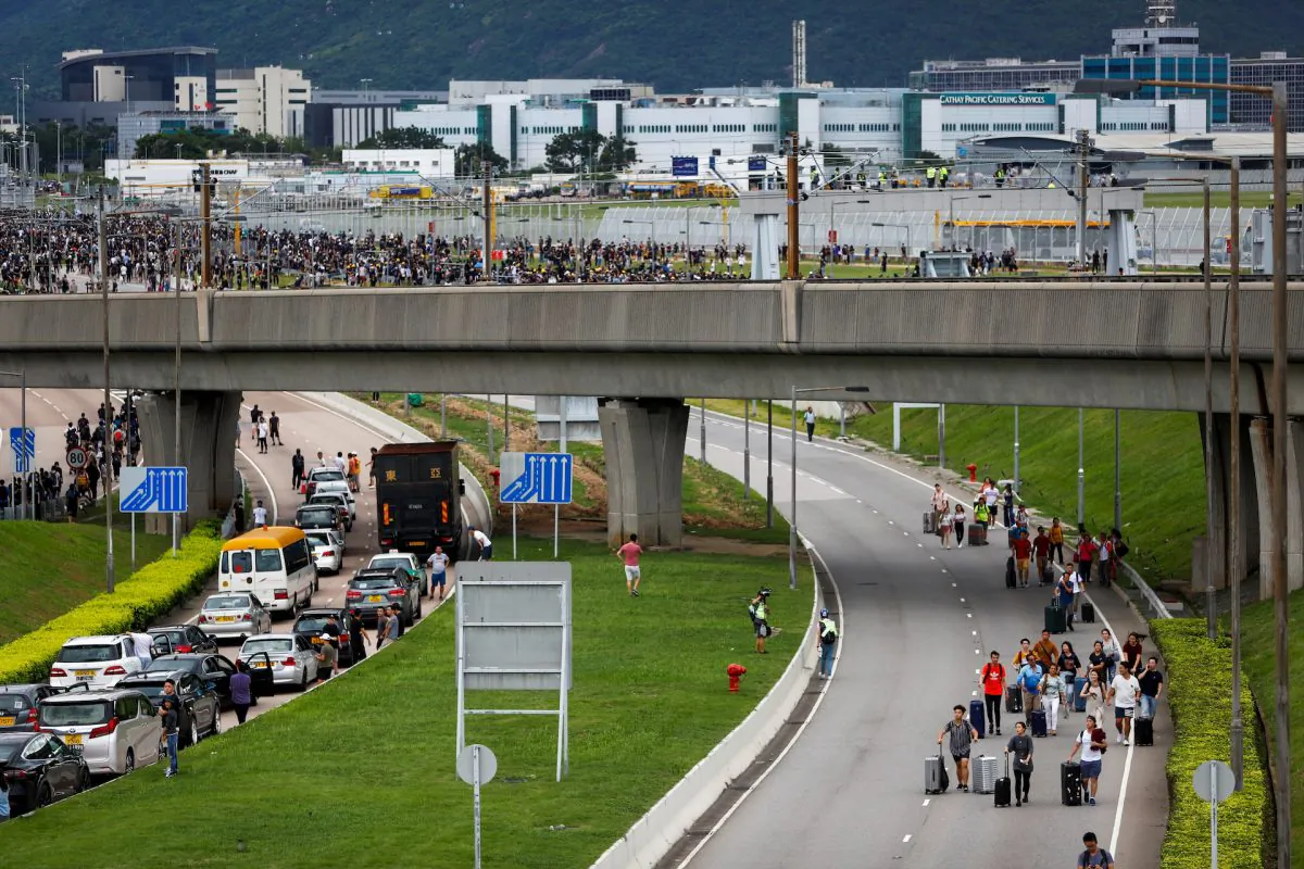 People try to get to Hong Kong International Airport as protesters gather in groups and try to block the highway, in Hong Kong, on Sept. 1, 2019. (Kai Pfaffenbach/Reuters)