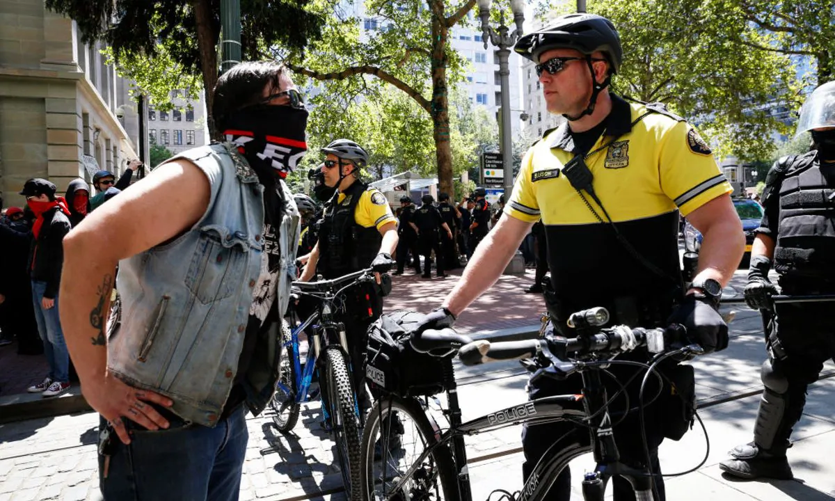 An unidentified protester clashes with a police officer during a demonstration between the left and right at Pioneer Courthouse Square, in Portland on June 29, 2019. These clashes led an ex-marine to stand outside Mayor's office on July 20 and warn about "slaughtering" Antifa that led FBI to confiscate his guns. (Moriah Ratner/Getty Images)