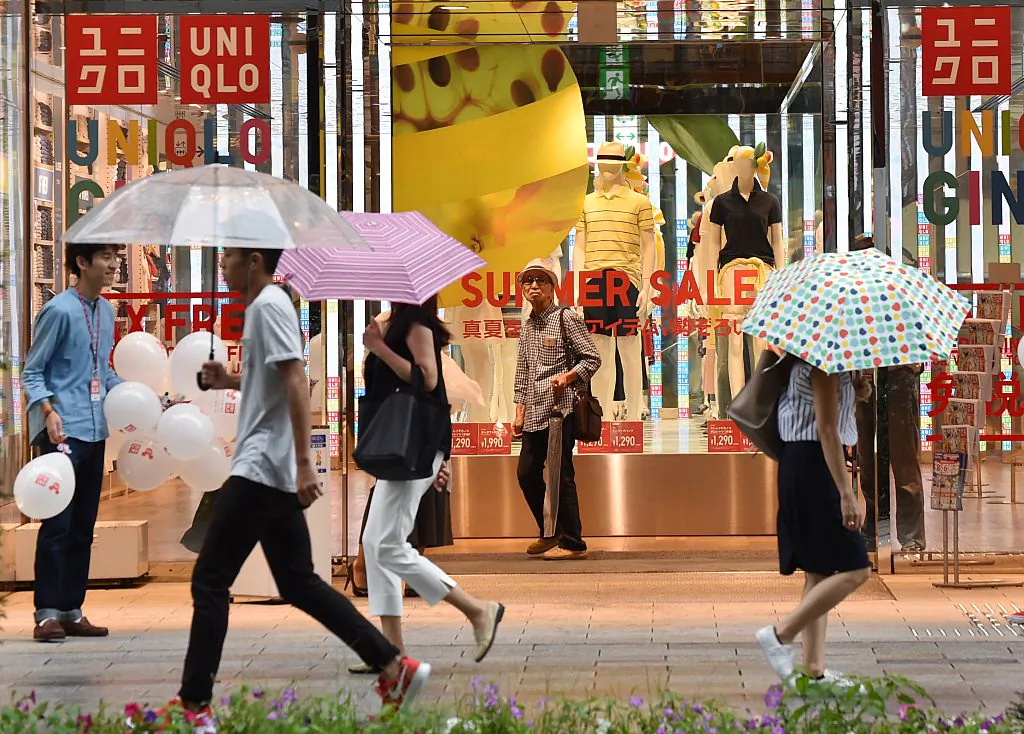 Pedestrians walk in front of a shop of Japan's Uniqlo-operator Fast Retailing in Tokyo, Japan, on July 15, 2016. (Kazuhiro Nogi/AFP/Getty Images)