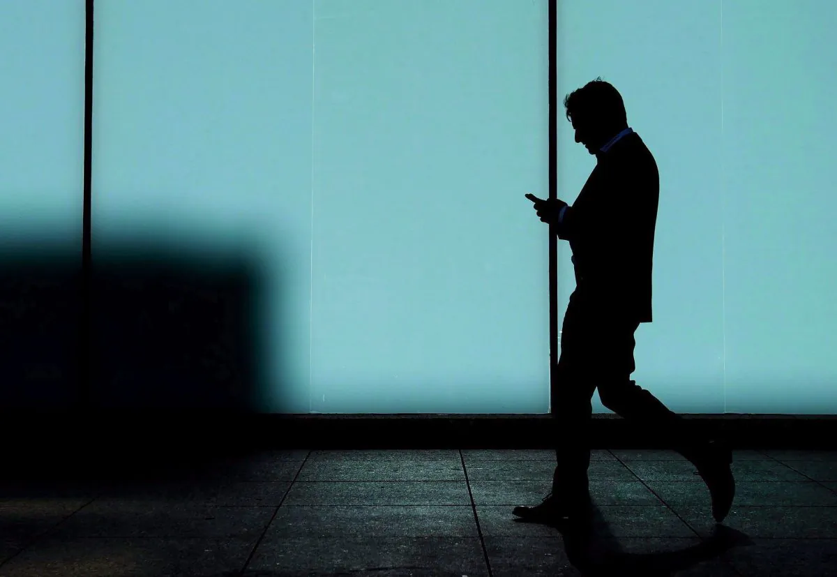 A man walks and texts on his smart phone in downtown Toronto on Oct. 30, 2017. Consumer advocates say a rare consensus is forming among the major political parties ahead of the federal election that Canadians need protecting from gouging by the country's big telecom companies. It's being called phone-bill populism, and it could be a make-or-break issue for the parties as they head toward the Oct. 21 vote. (The Canadian Press/Nathan Denette)
