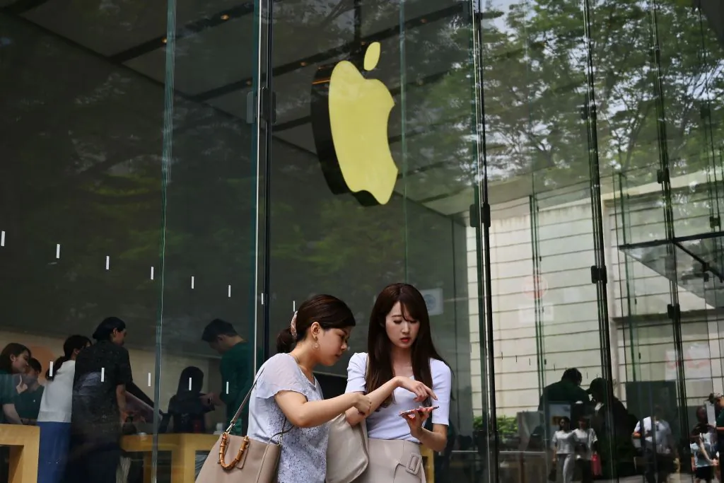 Women use their smartphones in front of an Apple store in Tokyo's Omotesando district on June 4, 2019. (CHARLY TRIBALLEAU/AFP/Getty Images)