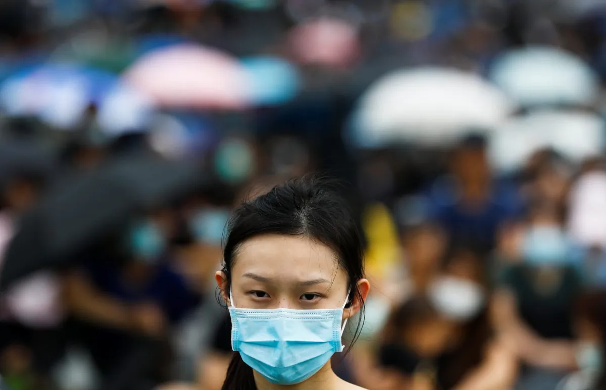 A protester covers her face with a mask during a general strike at Tamar Park in front of the government buildings in Hong Kong, on Sept. 3, 2019. (Kai Pfaffenbach/Reuters)