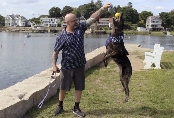 Former U.S. Navy SEAL James Hatch plays with his service dog,