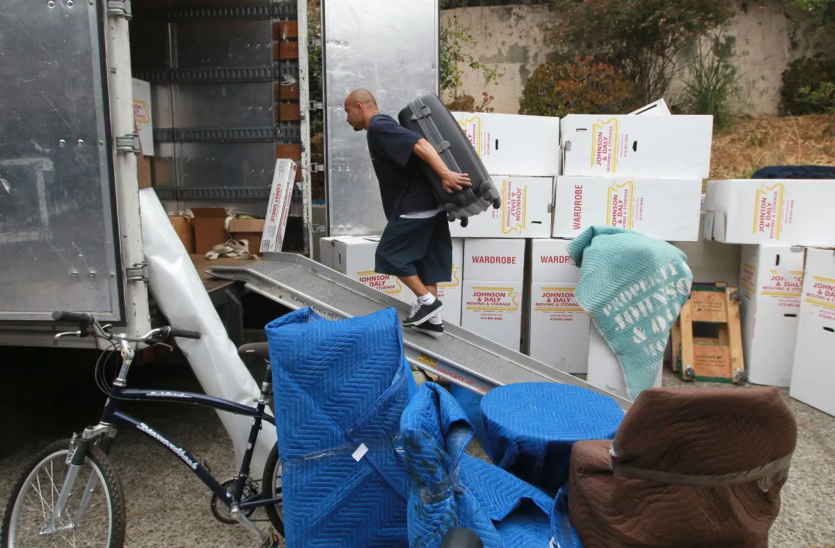 A worker moves a piece of furniture into a truck while moving a family in Tiburon, Calif., on Aug. 3, 2010. (Justin Sullivan/Getty Images)