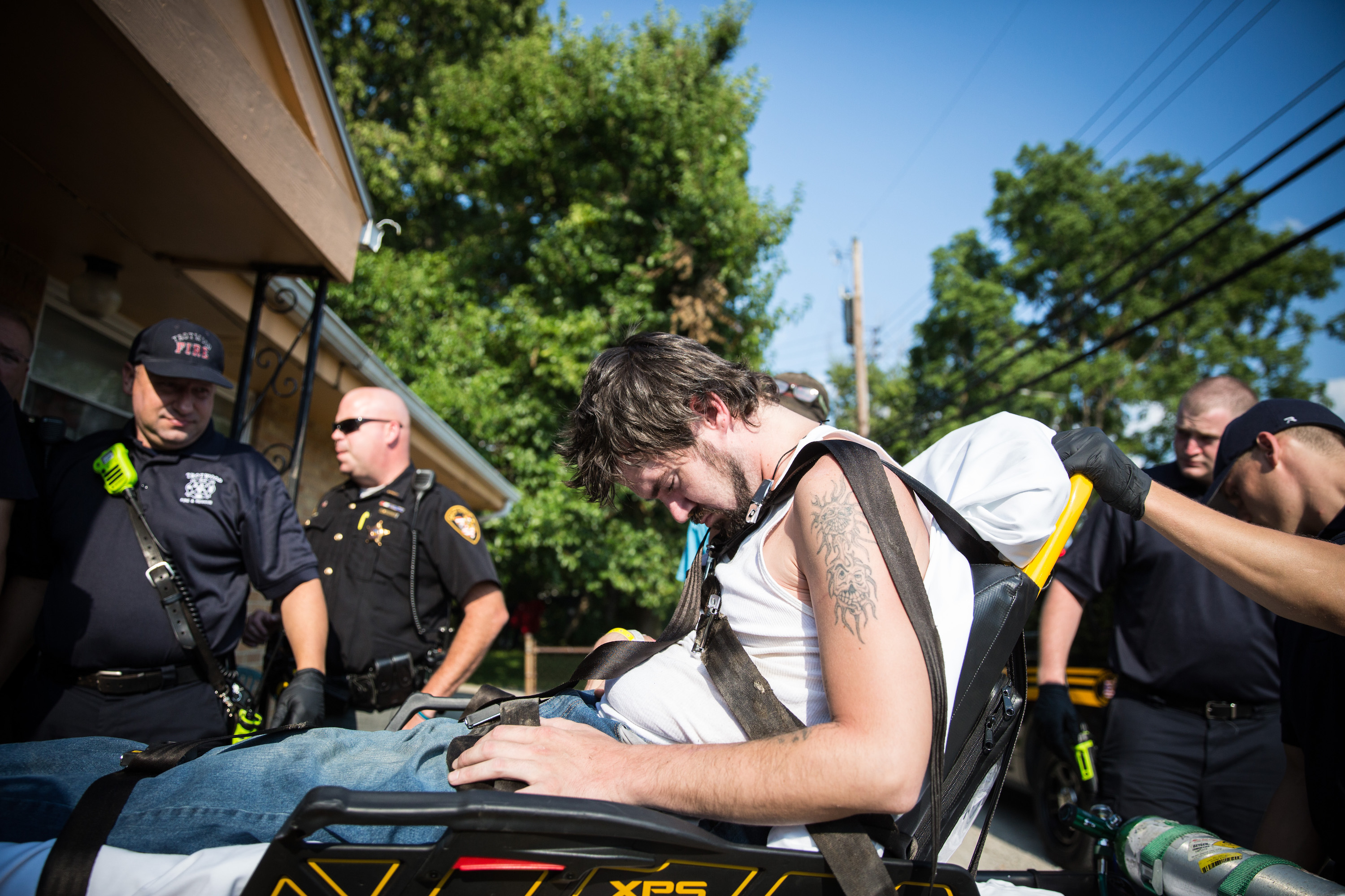 Local police, fire department, and deputy sheriffs help a man