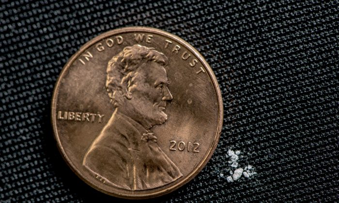 A fatal dose of fentanyl displayed next to a penny. (DEA)
