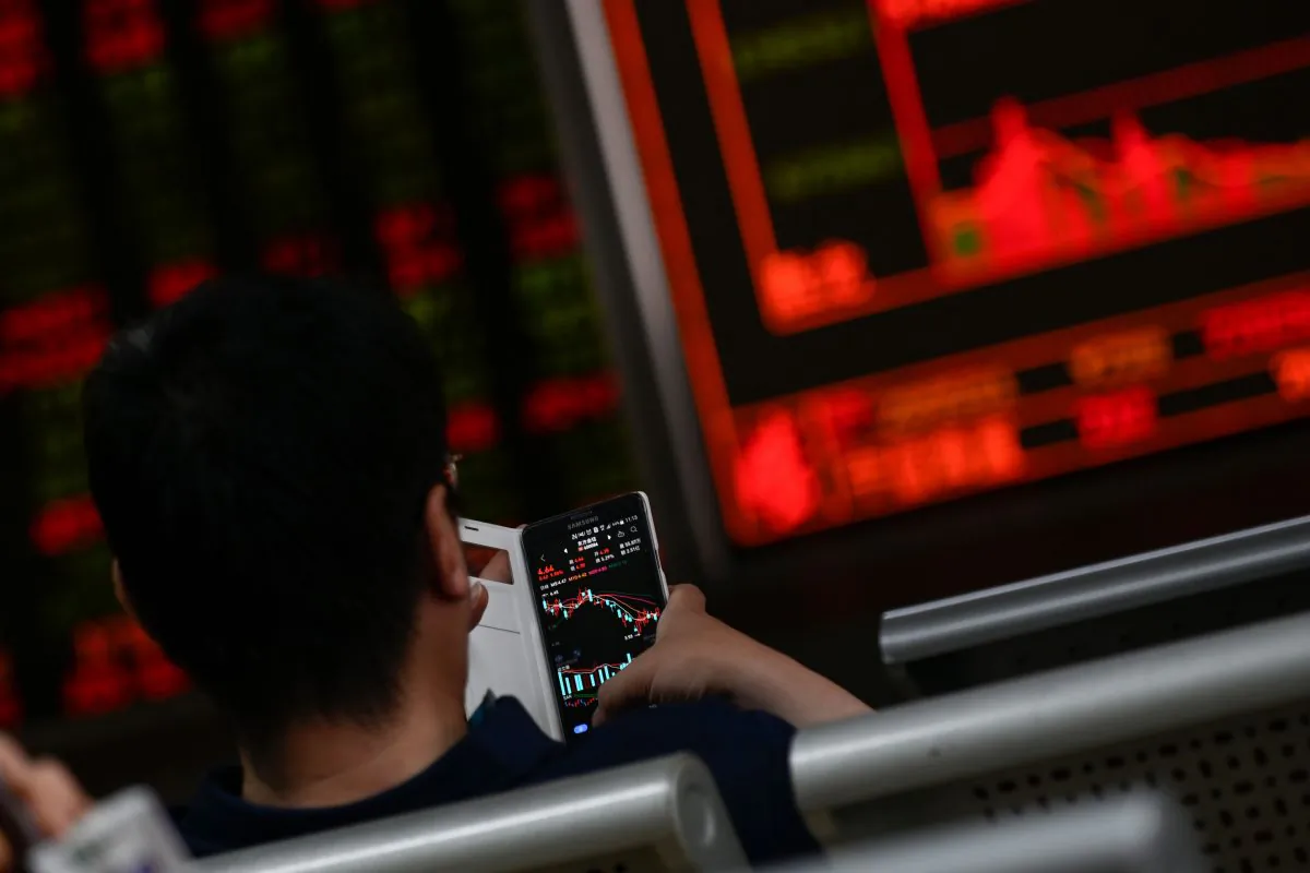 An investor looks at his mobile phone showing stock market movements at a securities company in Beijing  on May 14, 2019. (Wang Zhao/ AFP/Getty Images)