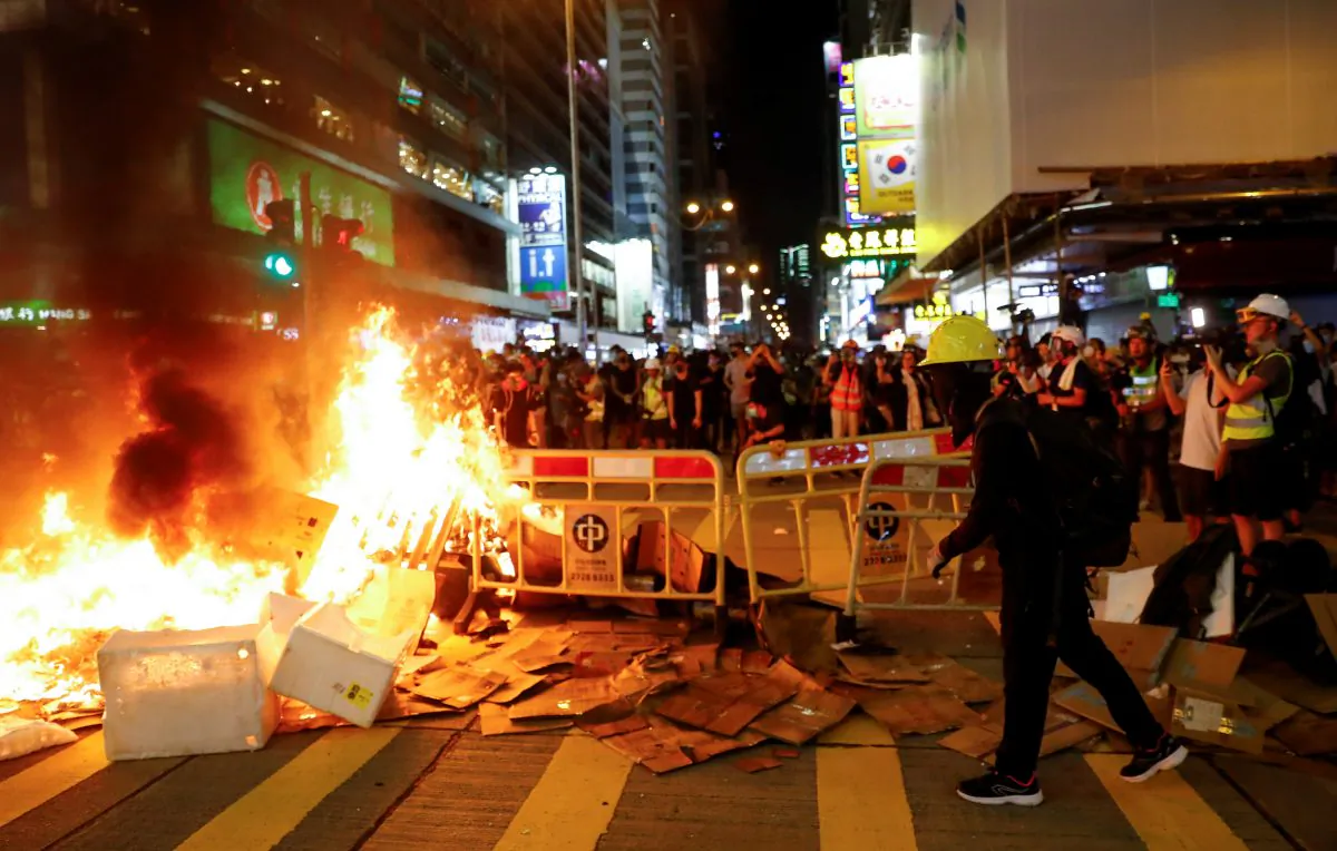 Protestors stand behind a burning barricade during a demonstration in Mong Kok district in Hong Kong, China on Sept. 6, 2019. (Kai Pfaffenbach/Reuters)