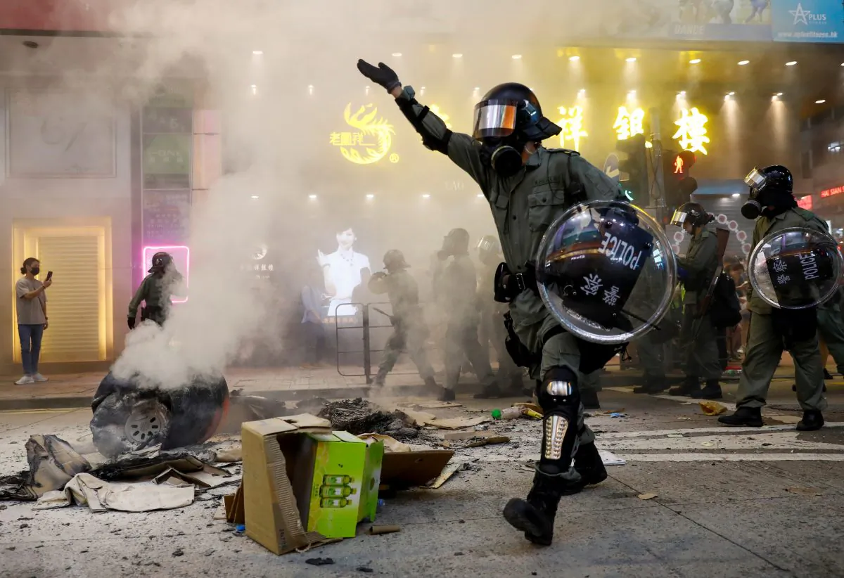 Riot police walk next to a street barricade during a demonstration in Mong Kok district in Hong Kong, China on Sept. 6, 2019. (Kai Pfaffenbach/Reuters)