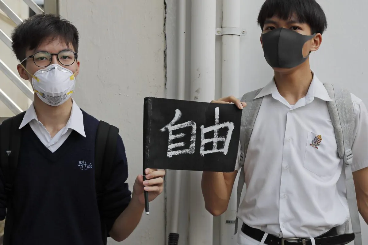 Students hold a placard reads "Freedom" as they form human chain outside a school in Hong Kong, China on Sept. 6, 2019. (Kin Cheung/AP)