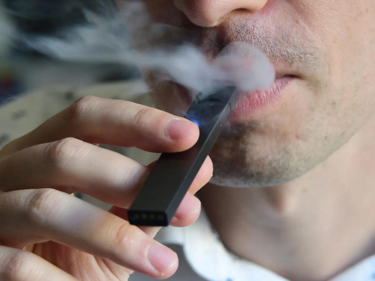 An illustration shows a man exhaling smoke from an electronic cigarette. (Eva Hambach/AFP/Getty Images)
