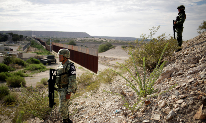 Soldiers assigned to the National Guard keep watch near a section of the border fence between Mexico and the United States as seen from Anapra neighborhood in Ciudad Juarez, Mexico, on Sept. 5, 2019. (Jose Luis Gonzalez/Reuters)