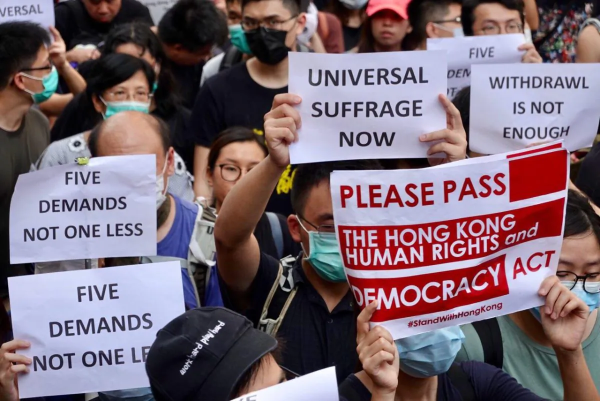Protesters hold up different signs during a march to the U.S. consulate in Hong Kong on Sept. 8, 2019. (Yu Gang/The Epoch Times)
