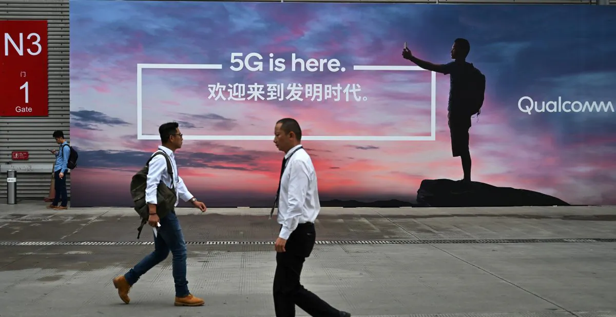 People walk past a poster advertising 5G internet at the Mobile World Congress (MWC 2019) introducing next-generation technology at the Shanghai New International Expo Centre (SNIEC) in Shanghai on Jun. 26, 2019. (Hector Retamal/AFP/Getty Images)