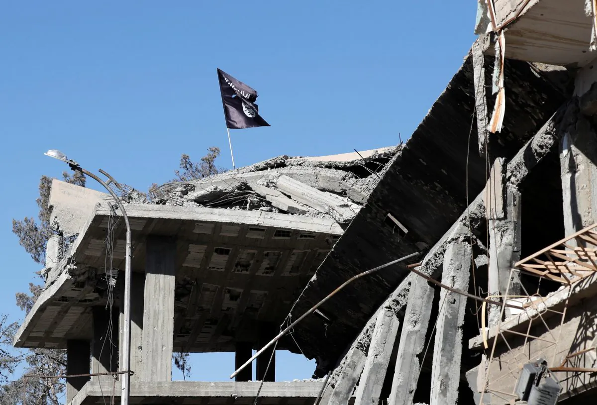 A flag of the ISIS terrorist group pictured above a destroyed house near the Clock Square in Raqqa, Syria, on Oct. 18, 2017. (Erik De Castro/Reuters)