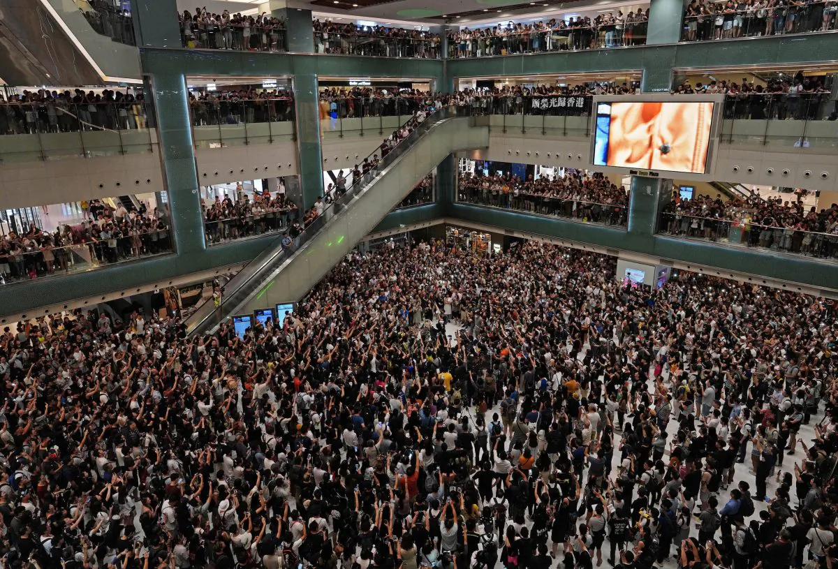 Local residents sing a theme song written by protesters "Glory be to Hong Kong" at a shopping mall in Hong Kong on Sept. 11, 2019. (Vincent Yu/AP Photo)