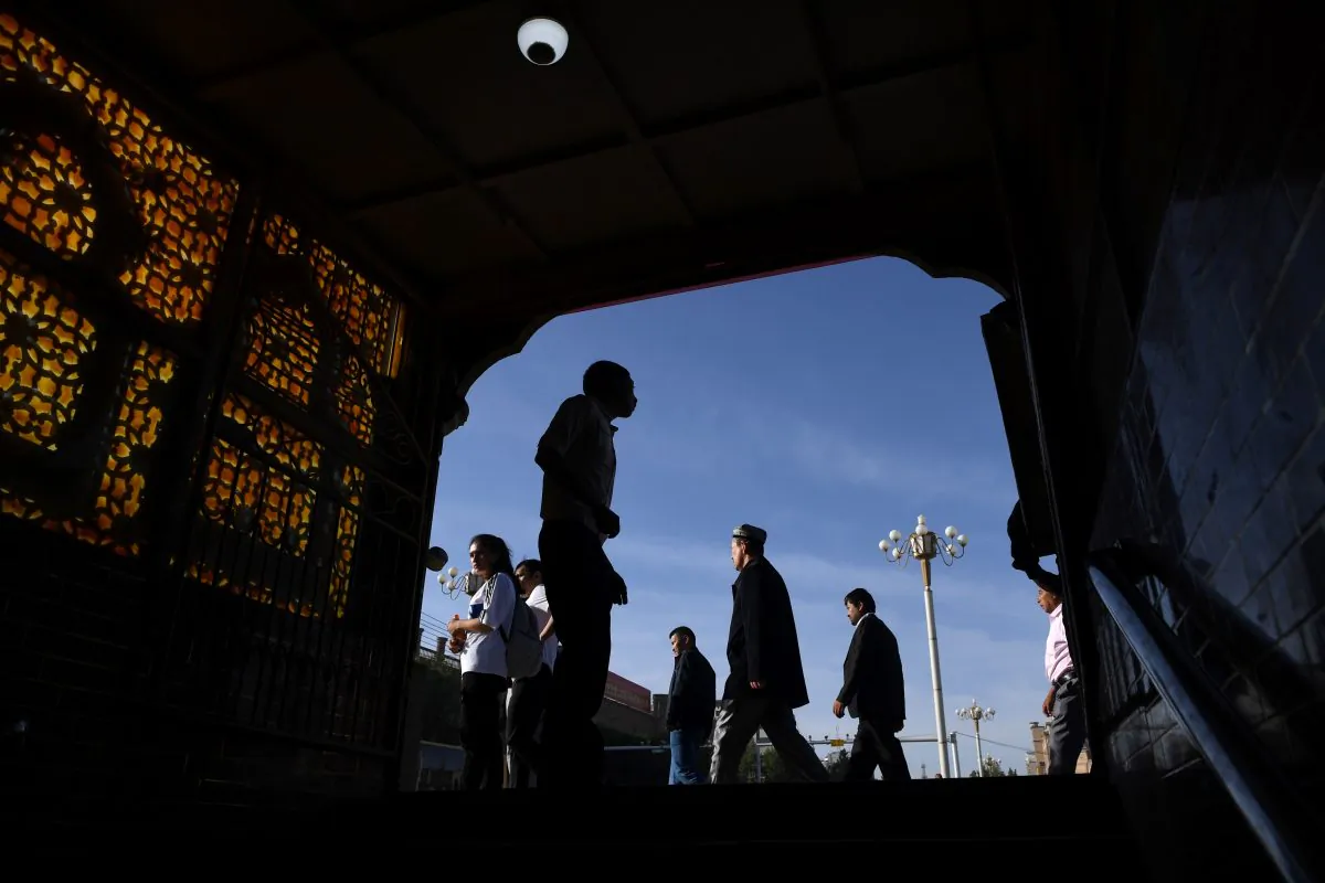 Uyghur men walking past the exit of an underpass after attending Eid al-Fitr prayers, marking the end of Ramadan, in Kashgar in China's northwest Xinjiang region on June 5, 2019. (Greg Baker/AFP/Getty Images)