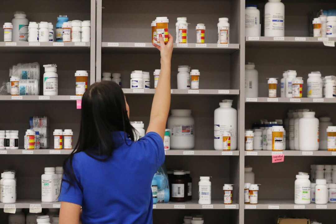 A pharmacy technician grabs a bottle of drugs at the central pharmacy of Intermountain Heathcare in Midvale, Utah, on Sept.10, 2018.  (Photo by George Frey/Getty Images)