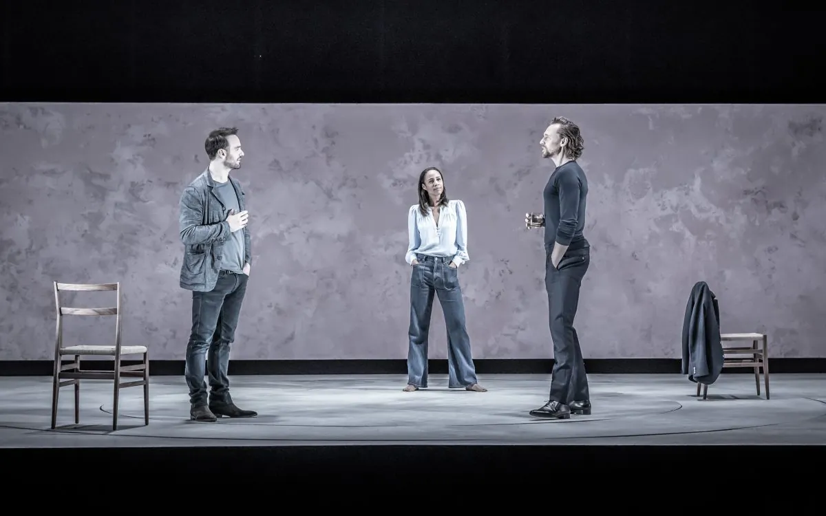 (L–R) The spare set and muted colors of the set and costumes focus audience attention on the nuances of the relationships. Charlie Cox, Zawe Ashton, and Tom Hiddleston star in “Betrayal,” here in London's Harold Pinter Theatre. (Marc Brenner)