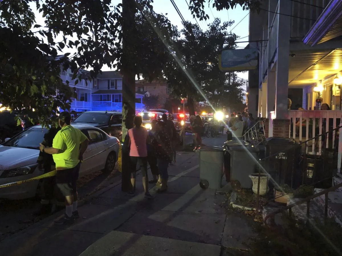 Onlookers watch first responders work the scene of a building structure damage in Wildwood, N.J., Saturday, Sept. 14, 2019. Officials say several people were injured when decks collapsed on one another at the three-story residence on the Jersey Shore. (Ahmad Austin/The Press of Atlantic City via AP)