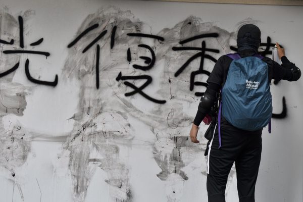 Um manifestante grafita a mensagem“Recupere Hong Kong” durante uma marcha pró-democracia em Hong Kong em 15 de setembro de 2019 (Nicolas Asfouri / AFP / Getty Images)