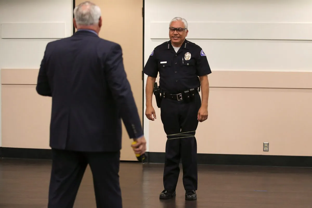 The city of Bell's chief of police Carlos Islas reacts after Wrap Technologies CEO Michael Rothans tests on him a new non-lethal weapon that discharges an 8 foot bola style Kevlar tether at 640 feet per second to entangle a subject, in Bell Police Department, California, Sept. 5, 2019. (Mike Blake/Reuters)
