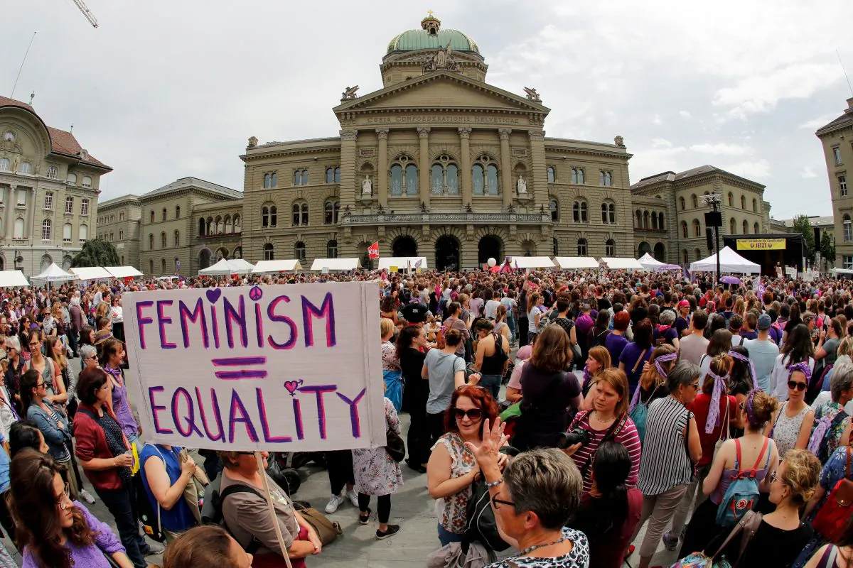 A woman holds a sign reading "Feminism = Equality" as she takes part in a nation-wide women's strike for wage parity outside the federal palace in the Swiss capital Bern on June 14, 2019. Nearly 30 years after staging a first strike, women across Switzerland stage mass demonstrations for equal pay. Events planned throughout the day range from pram marches, to whistle concerts, to extended lunch breaks and giant picnics, with huge demonstrations planned on June 14 evening in several cities, including in front of the government in Bern. (Stefan Wermuth/AFP/Getty Images)