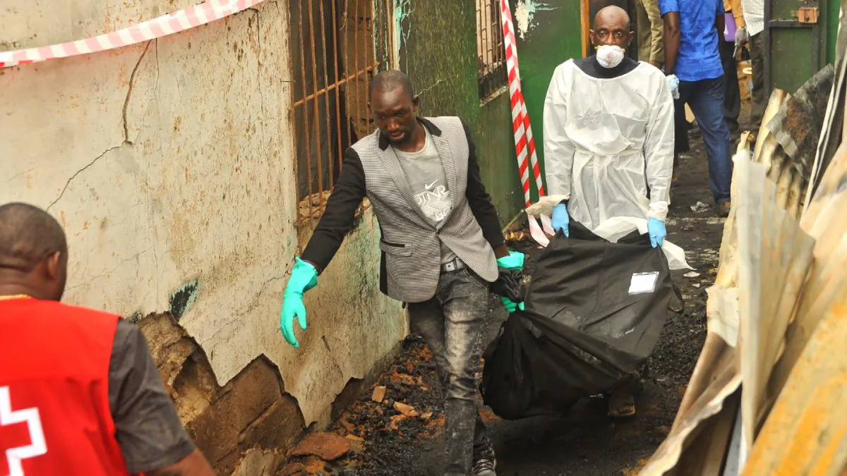 Rescuers hold a body after a fire at a Koranic school that killed at least 27 children and two teachers in Monrovia, Liberia, on Sept. 18, 2019. (ZOOM DOSSO/AFP/Getty Images)