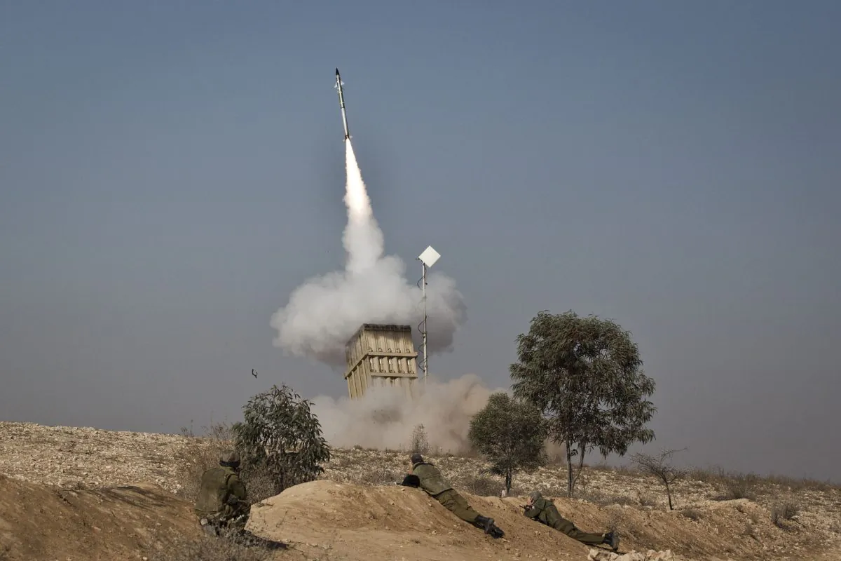 An Israeli soldier lies on the ground as missiles are fired from an Iron Dome anti-missile station near the city of Beer Sheva, Israel on Nov. 15, 2012. (Ilia Yefimovich/Getty Images)