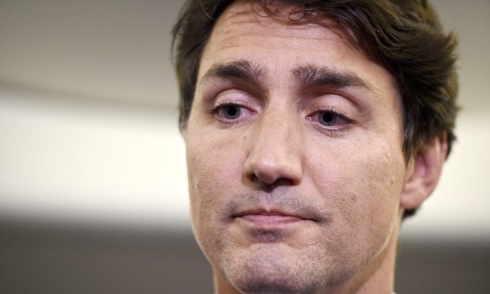 Canadian Prime Minister and Liberal Party leader Justin Trudeau reacts as he makes a statement in regards to a photo coming to light of himself from 2001, wearing "brownface," during a scrum on his campaign plane in Halifax, Nova Scotia, Wednesday, Sept. 18, 2019. (Sean Kilpatrick/The Canadian Press via AP)
