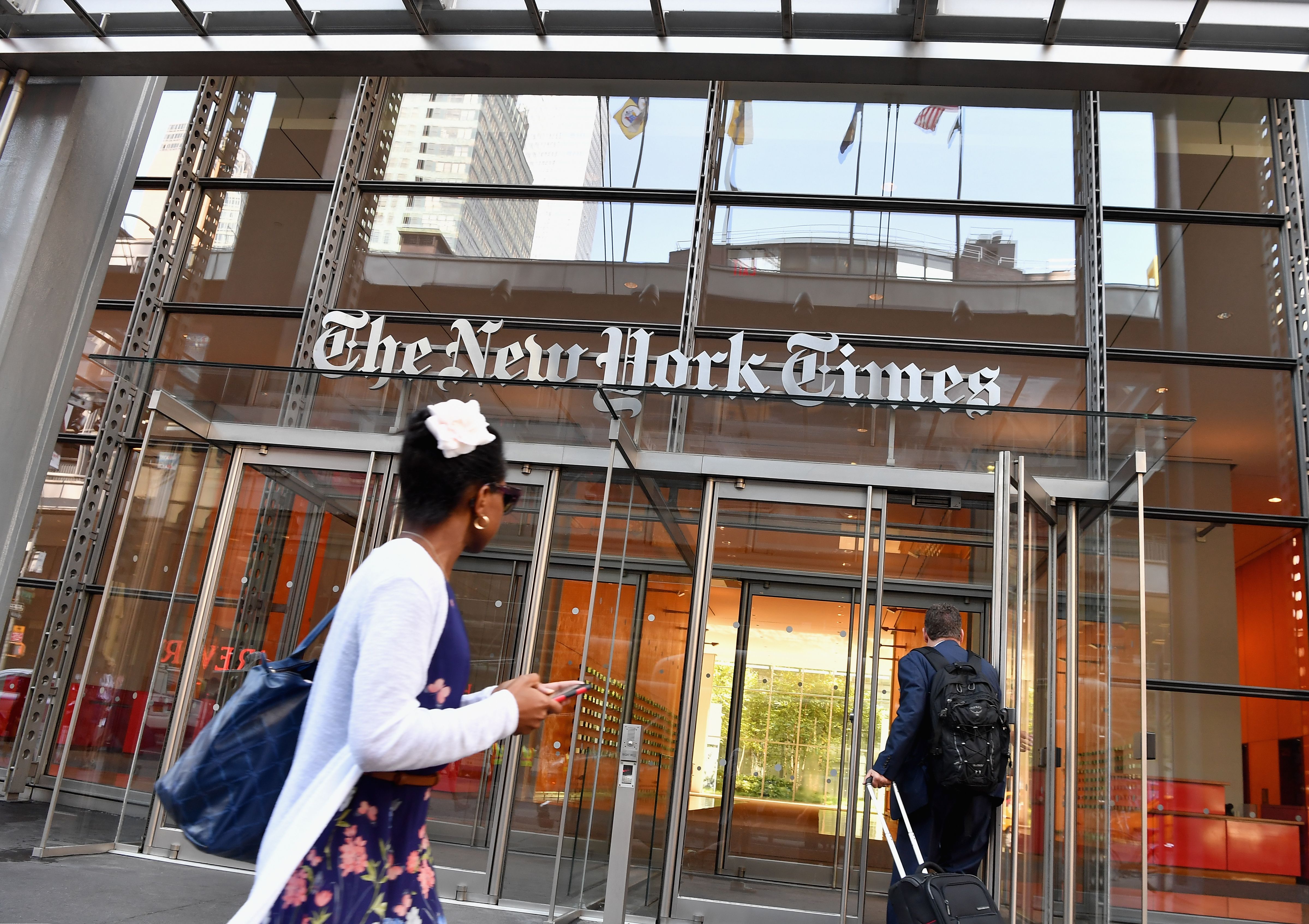 People walk by the front of the New York Times