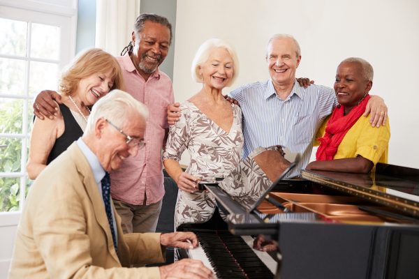 Group Of Seniors Standing By Piano And Singing Together - Image