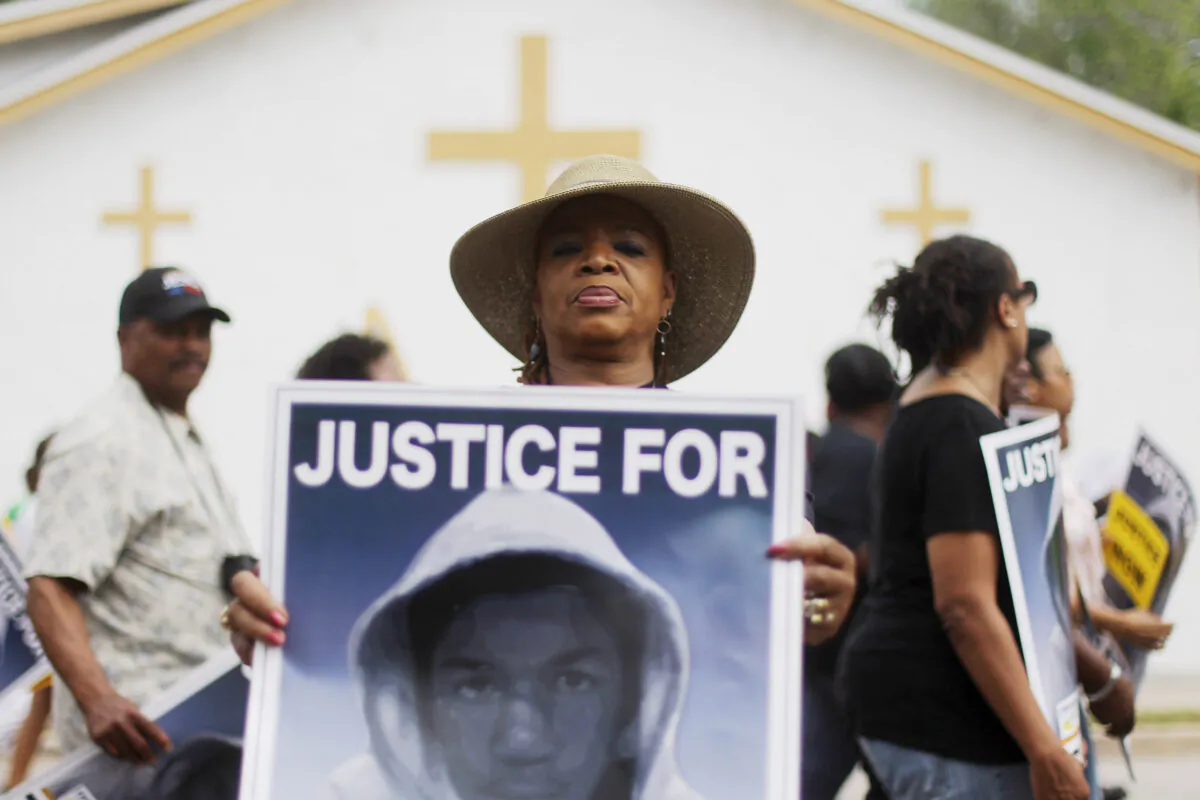 A Trayvon Martin supporter displays her sign during a march on the way to a rally in front of the Sanford Police Department in Sanford, Florida, on March 31, 2012. Rev. Jesse Jackson, Rev. Al Sharpton, and NAACP President Benjamin Jealous were amongst the supporters demanding Zimmerman's arrest. (Mario Tama/Getty Images)
