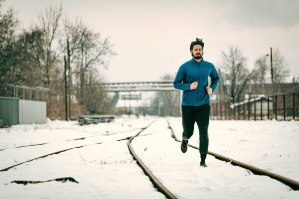 Active young man running during the winter