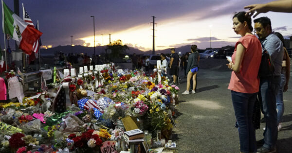 People gather at a makeshift memorial