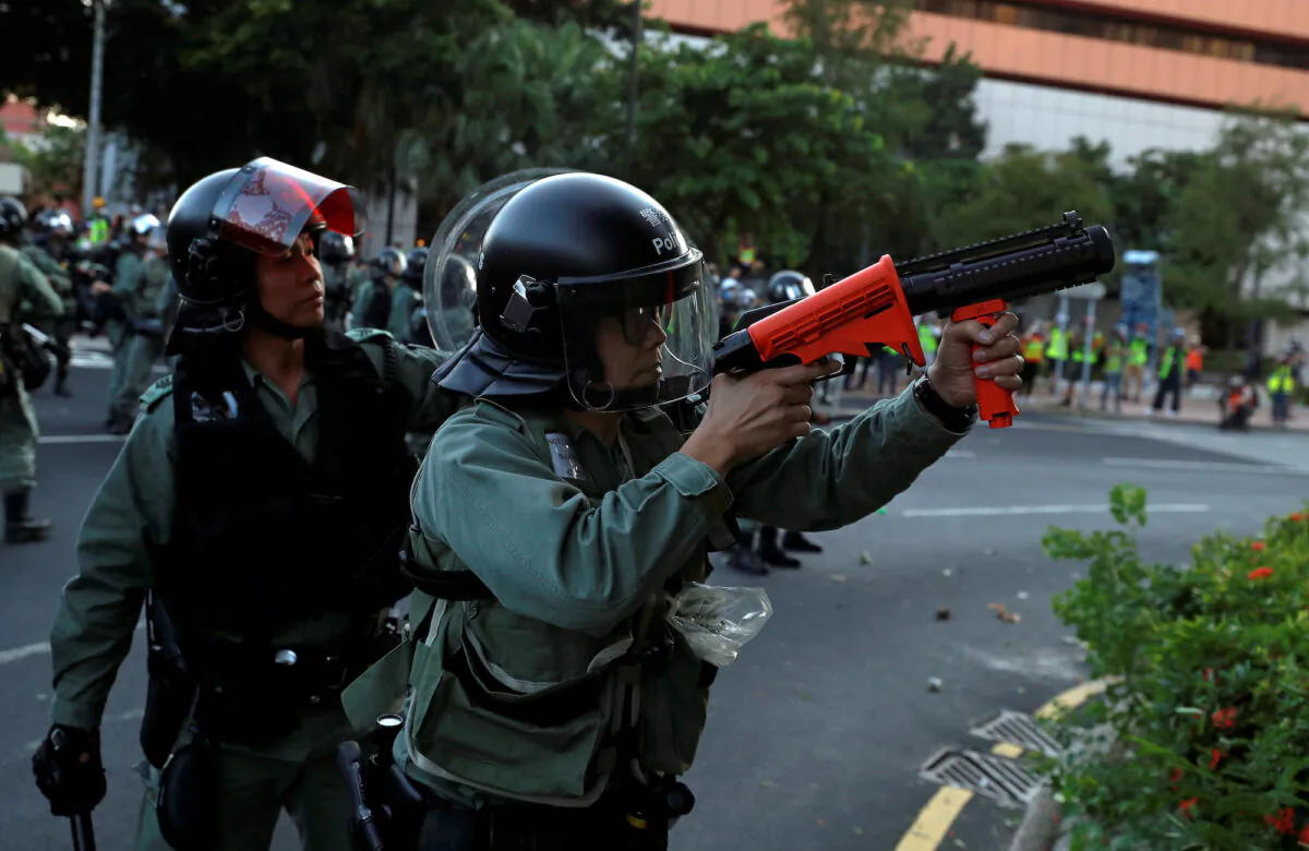 A police officer aims as anti-government protesters demonstrate in Sha Tin, Hong Kong, on September 22, 2019. (REUTERS/Jorge Silva)