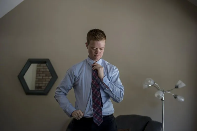 Evan Minton, who was refused gender transition surgery, adjusts his tie in Orangeville, Calif., on Aug. 30, 2019. (Jose Luis Villegas/The Sacramento Bee via AP)