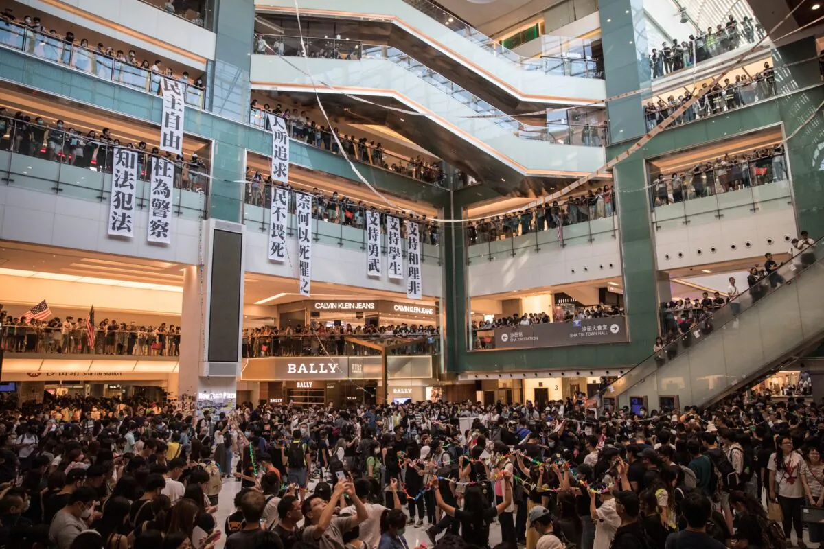 Hong Kong pro-democracy protesters sing songs and chant slogans during a rally inside a shopping mall in Sha Tin on Sept. 22, 2019. Pro-democracy protesters have continued demonstrations across Hong Kong, calling for the city's Chief Executive Carrie Lam to immediately meet the rest of their demands, including an independent inquiry into police brutality, the retraction of the word “riot” to describe the rallies, and genuine universal suffrage, as the territory faces a leadership crisis. (Chris McGrath/Getty Images)