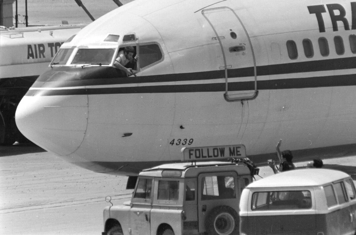 A hijacker points a weapon toward an ABC news media crew from the window of the cockpit of the Trans World Airlines jet as the American television crew approaches the jet for an interview at Beirut International Airport, Lebanon, on June 19, 1985. (Herve Merliac/AP Photo)